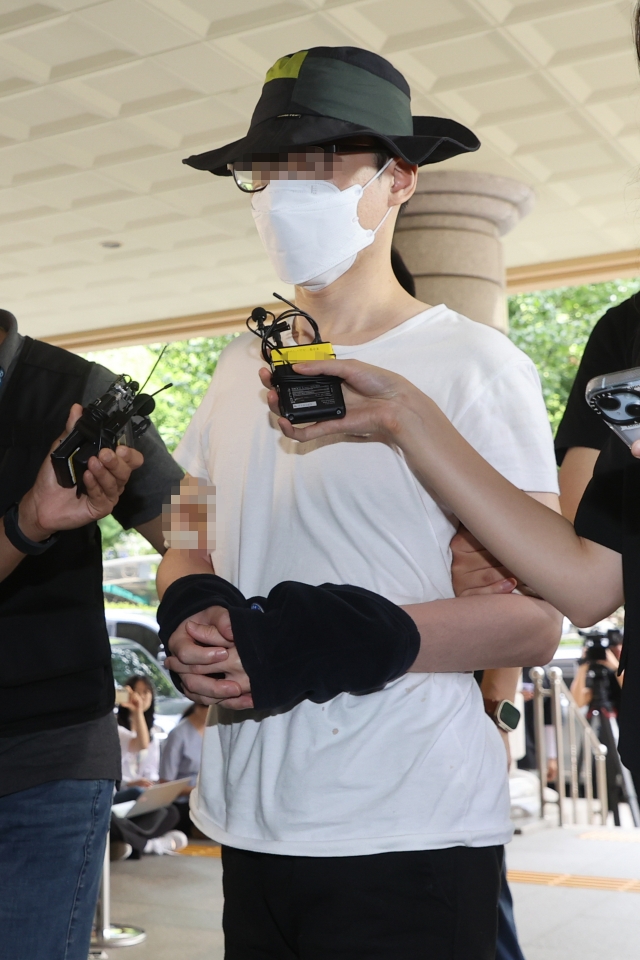 The suspect in a recent murder by sword case speaks to reporters before entering the Seoul Western District Court in Mapo-gu, Seoul, Thursday. (Yonhap)