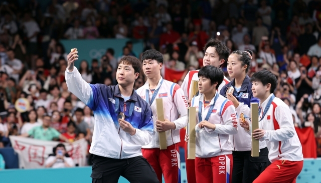 South Korea's Lim Jong-hoon (left) and Shin Yu-bin (second from right) take a victory selfie with the other medalists of the mixed doubles table tennis event at the Paris Olympics at South Paris Arena 4 in Paris on July 30. (Yonhap)