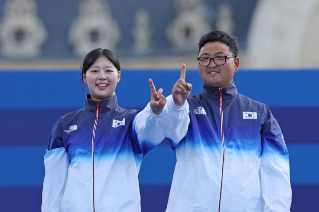 Lim Si-yeon (left) and Kim Woo-jin pose after winning the mixed team archery event at the Paris Games at Invalides in Paris on Friday. (Yonhap)