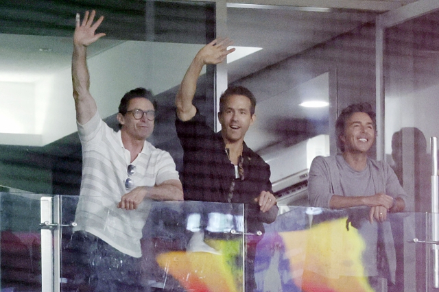 (From left) Hugh Jackman, Ryan Reynolds and director Shawn Levy are seen watching a 2024 KBO League game between the LG Twins and Kiwoom Heroes at Gocheok Sky Dome in Seoul, July 3. (Newsis)