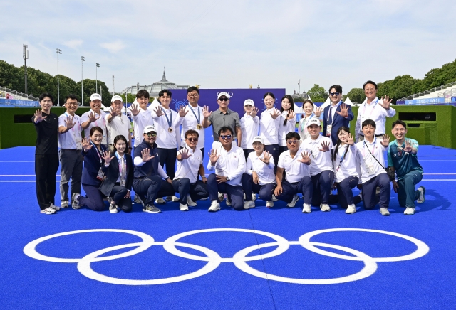 S. Korean national archers, members of the Korea Archery Association, coaching staff and former national archers each hold up five fingers to celebrate the country's five gold medals won at the 2028 Olympic Games in Paris on Sunday. (Korea Archery Association)