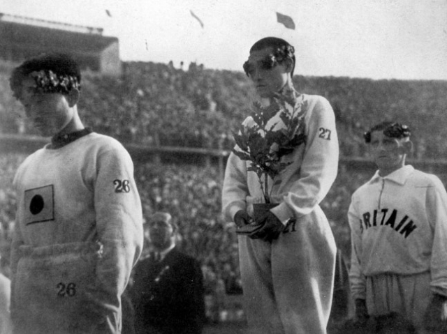 Marathoners Nam Seung-ryong (left) and Sohn Kee-chung (center) lower their gaze during the medal ceremony at the 1936 Berlin Olympics. (Korean Sport & Olympic Committee)