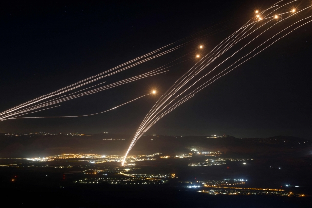 Rockets fired from southern Lebanon are intercepted by Israel's Iron Dome air defence system over the Upper Galilee region in northern Israel, on Sunday, amid ongoing cross-border clashes between Israeli troops and Lebanon's Hezbollah fighters. Middle East tensions soared Saturday as Iran and its allies readied their response to the assassination of Hamas's political leader, blamed on Israel, spurring fears of a regional war. (AFP)