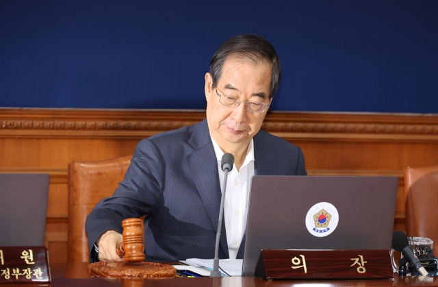 Prime Minister Han Duck-soo bangs the gavel during a Cabinet meeting at the government complex in Seoul on Tuesday. (Yonhap)