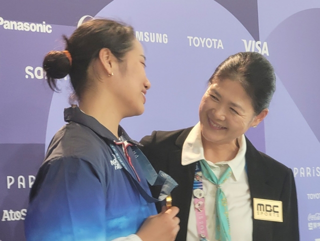 Ahn Se-young (left) is congratulated by Bang Soo-hyun, first Korean to win a singles badminton event in the Olympics, after winning the gold medal in the women's singles badminton event at the Paris Olympics at Porte de La Chapelle Arena in Paris on Monday. (Yonhap)