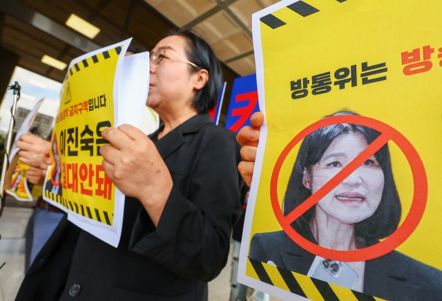 Labor union members of South Korean journalists hold placards while filing a complaint against Lee Jin-sook, chief of the Korea Communications Commission, at the Seoul Central District Prosecutors' Office, July 31. (Yonhap)