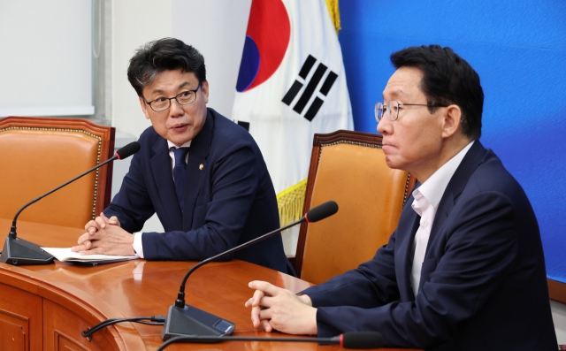 Policy chiefs of the ruling and main opposition parties, Democratic Party's Rep. Jin Sung-joon (left) and People Power Party's Rep. Kim Sang-hoon, hold talks at a meeting held at the National Assembly Wednesday. (Yonhap)