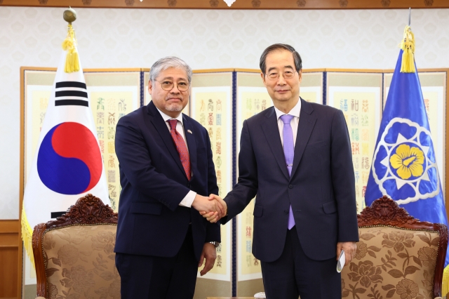 Prime Minister Han Duck-soo shakes hand with Philippine Secretary of Foreign Affairs Enrique Manalo in Seoul on Wednesday. (Yonhap)