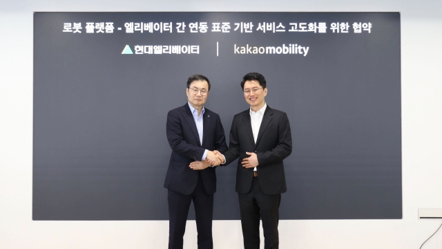 Hyundai Elevator CEO Cho Jae-cheon (left) and Kakao Mobility CEO Ryu Geung-sun shake hands following the signing ceremony in Seongnam, Gyeonggi Province, Wednesday. (Hyundai Elevator)