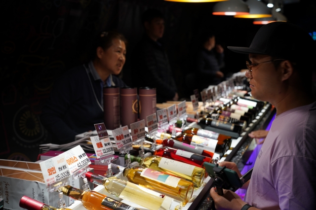 A visitor views wines made in Korea on display at the wine cave in Gwangmyeong Cave, Tuesday. (Lee Si-jin/The Korea Herald)