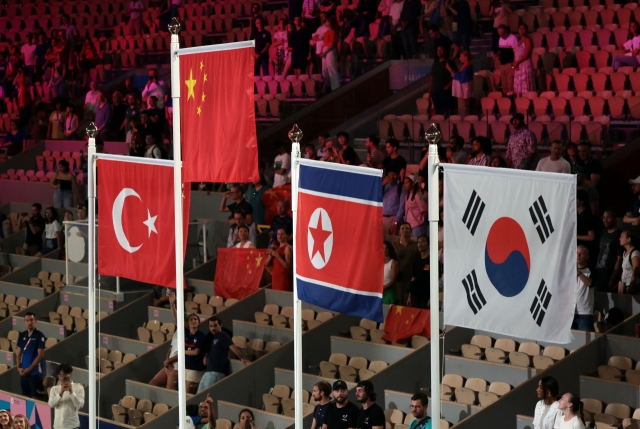 The flags of South (right) and North Korea (second from right) are displayed next to each other in the medal ceremony for the women's 54-kilogram boxing event at the Paris Olympics on Thursday, as female boxers from the two countries were both awarded the bronze. (Yonhap)