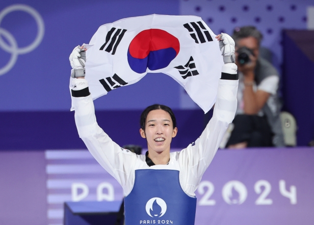 Kim Yu-jin holds the South Korean flag over her head after winning the finals of the women's -57-kilogram taekwondo event at the Paris Olympics at Grand Palais in Paris on Thursday. (Yonhap)