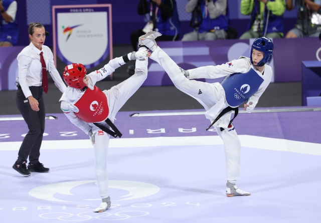 Kim Yu-jin of South Korea (right) battles Nahid Kiani of Iran in the final of the women's -57-kilogram taekwondo event at the Paris Olympics at Grand Palais in Paris on Thursday. (Yonhap)