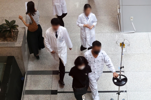 As resident doctors continue to refuse returning to work in protest of medical school quota increases, medical staff and patients are seen moving through a major hospital in Seoul on Aug. 6. (Yonhap)