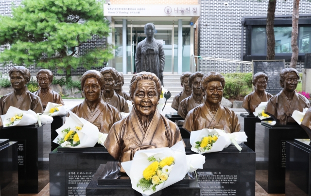 Flowers are placed in front of the busts of the deceased comfort women at the House of Sharing in Gwangju, Gyeonggi Province, on Saturday. (Yonhap)