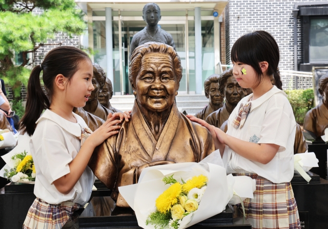 Children gaze at the busts of the deceased comfort women at the House of Sharing in Gwangju, Gyeonggi Province, on Saturday. (Yonhap)