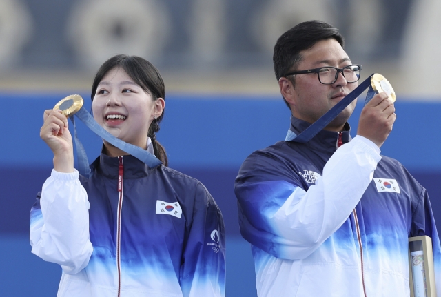 Lim Si-hyeon (left) and Kim Woo-jin of South Korea pose with their gold medals won in the archery mixed team event at the Paris Olympics at Invalides in Paris. (Yonhap)