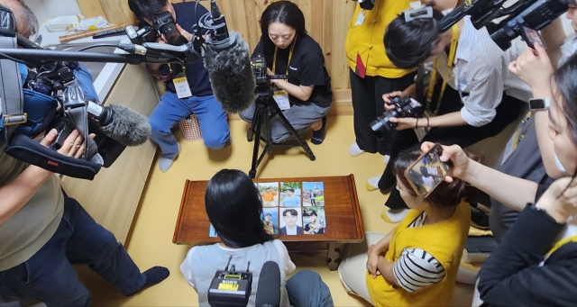 A participant selects her dinner date from photos during a matchmaking templestay at Naksansa in Yangyang County, Gangwon Province, Aug. 9. (Choi Si-young/The Korea Herald)