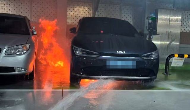 A fire has ignited beneath a Kia EV6 in a parking area in Geumsan, South Chungcheong Province on Aug. 6. (Yonhap)