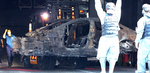 Police remove an electric Mercedes-Benz EQE 350 sedan from the underground parking lot of an apartment building in Incheon, 27 kilometers west of Seoul, on Aug. 5, following the completion of their investigation. The car had exploded and caught fire on Aug. 1, leading to 22 residents and a firefighter being hospitalized. The incident also resulted in around 40 vehicles being burned and damage to an additional 100 cars in the parking lot. (Yonhap)