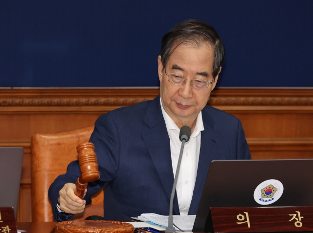 Prime Minister Han Duck-soo taps the gavel during a Cabinet meeting held Tuesday. (Yonhap)