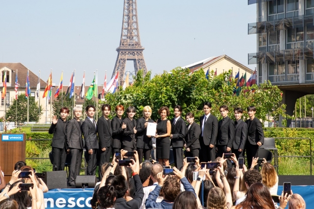 Boy band Seventeen poses with UNESCO Director-General Audrey Azoulay at the ceremony to appoint the group as UNESCO Youth Goodwill Ambassadors, at the UNESCO headquarters in Paris, June 26. (Pledis Entertainment)