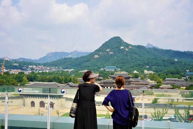 Visitors view Gyeongbokgung from the rooftop of the National Museum of Korean Contemporary History in Jongno-gu, central Seoul on Tuesday. (Lee Si-jin/The Korea Herald)