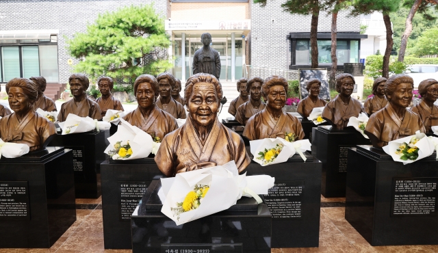 Flowers are laid upon the busts of the late victims of sexual slavery by the Japanese military during World War II at the House of Sharing, a facility dedicated to such women, euphemistically called 