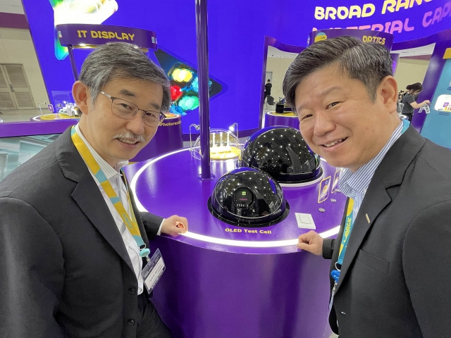 Merck Korea managing director Kim Woo-kyu (left) and Yun Yong-kuk, country lead for display solutions at Merck, pose with OLED test cells at Merck Korea's exhibition booth at the K-Display 2024 exhibition in Seoul, Wednesday. (Merck Korea)