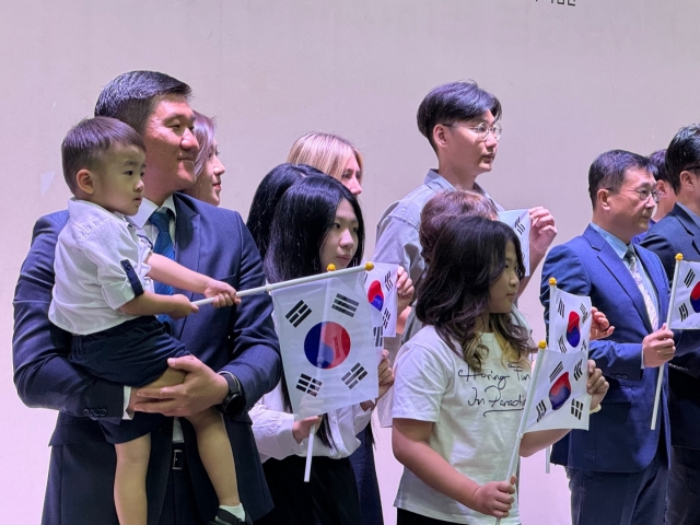 Pavel Tsoi (left), holding his nephew Danila Tsoi, poses for photos at a naturalization ceremony at the National Memorial of the Korean Provisional Government in Seodaemun-gu, Seoul, Monday. Including Tsoi and his five relatives from Russia, 27 descendants of 14 independence activists obtained Korean nationality. (Park Ga-young/The Korea Herald)