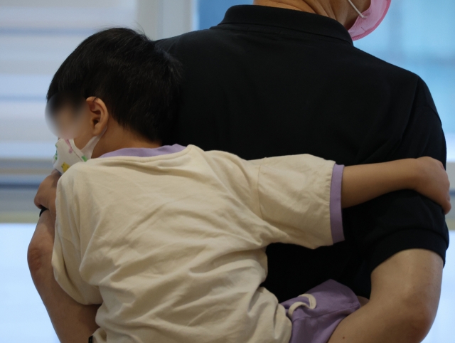 A child patient is seen at a hospital wearing a mask (Yonhap)