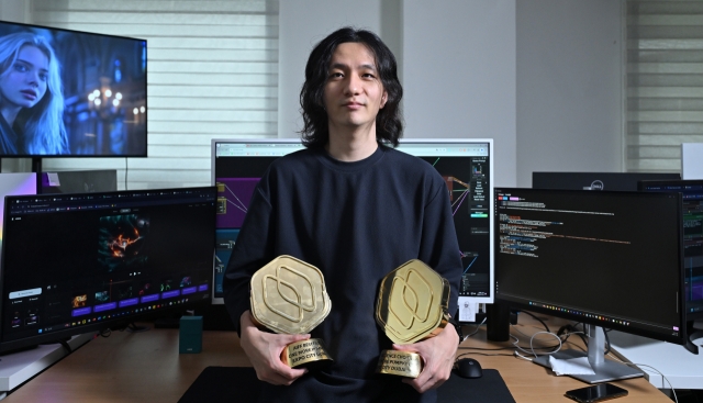 AI film director Kwon Han-sl holds the Grand Prize and Audience Award trophies he received at the Dubai International AI Film Festival in February, at his office in Seoul, July 22. (Im Se-jun/The Korea Herald)