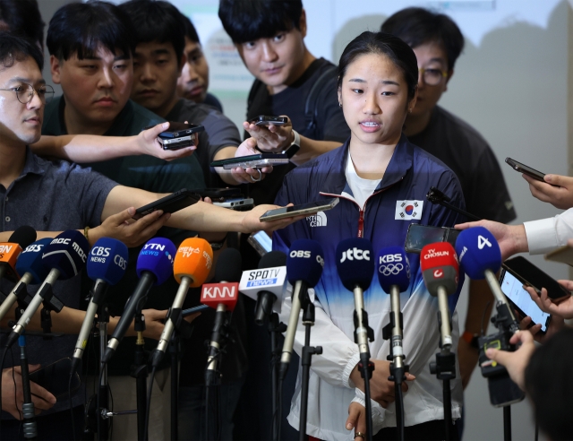 Olympic badminton champion An Se-young answers questions after arriving at Incheon International Airport, Aug. 7. (Yonhap)