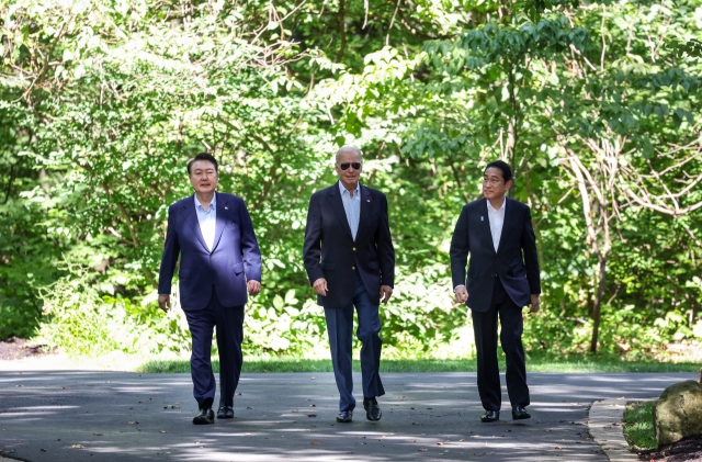 In this file photo from August 18, 2023, South Korean President Yoon Suk Yeol (left), US President Joe Biden (center), and Japanese Prime Minister Fumio Kishida are pictured walking together following a trilateral summit at the Camp David presidential retreat in Maryland. (Yonhap)