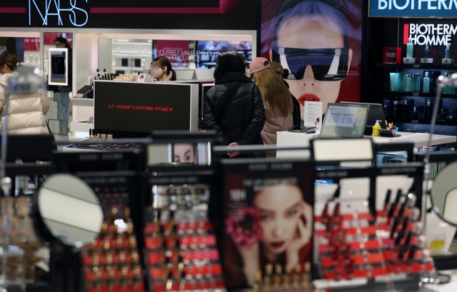 Visitors browse cosmetic products at a duty-free store in Seoul. (Newsis)