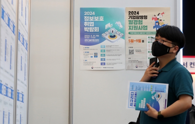 A jobseeker checks job posts at a fair held in southern Seoul on May 31. (Newsis)