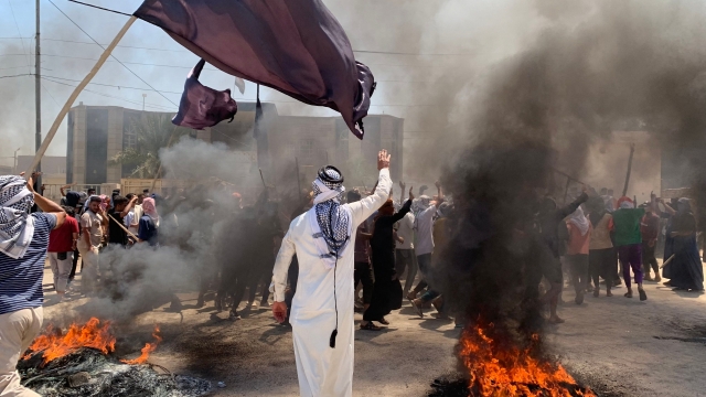 A man in traditional dress takes part in a demonstration as tires burn in front of the mayor's office to protest daily power cuts and water shortages during the extreme heat of summer, in Al-Mahnawiya, in the southern Iraqi province of Diwaniyah, July 21. (AFP-Yonhap)