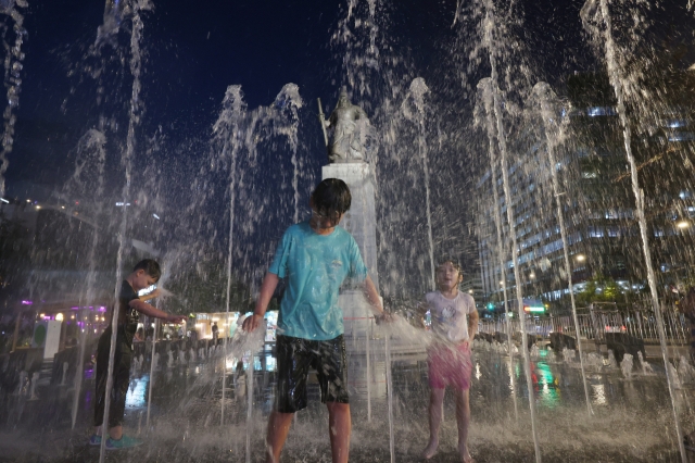 Children play at the fountain in Gwanghwamun Square in Seoul on August 13. (Yonhap)