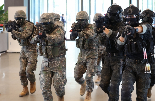 The South Korean army and police conduct a joint live anti-terror drill at a bank branch in Daegu on Monday. (Yonhap)