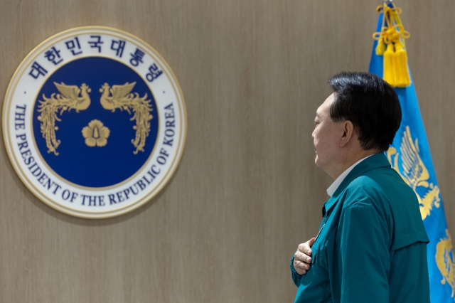 President Yoon Suk Yeol salutes to the national flag as he presided over a Cabinet meeting in his office in Seoul Monday. (Presidential office)