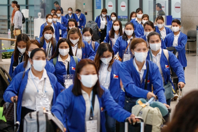 A hundred Filipina domestic helpers arrive at Incheon Airport on Aug. 6. (Pool photo via Yonhap)