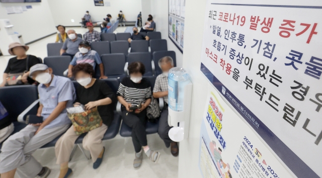 Patients wait in line wearing masks at a university hospital in Daegu, Tuesday. (Yonhap)