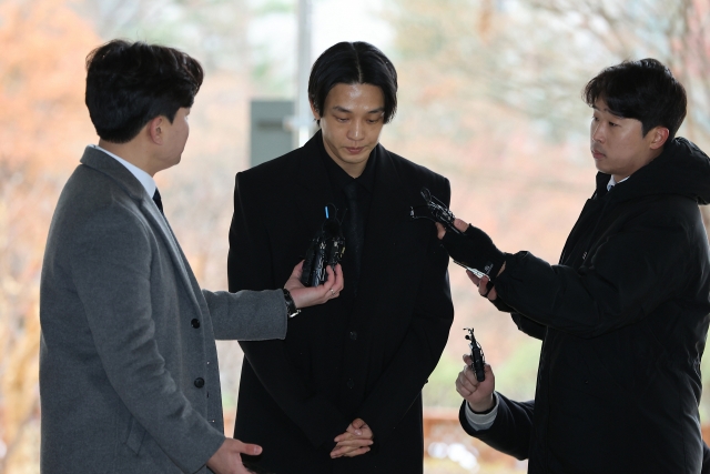 Actor Yoo Ah-in stands before the photo line and answers the press before entering the Seoul Central District Court on Dec. 22, 2023. (Lee Sang-sub/The Korea Herald)