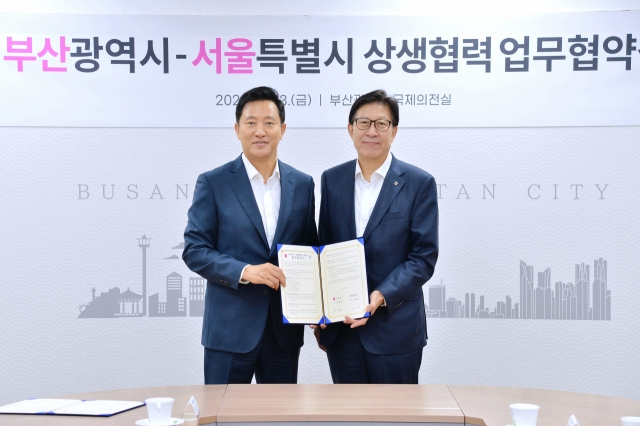 Seoul Mayor Oh Se-hoon (left) signs a memorandum of understanding with Busan Mayor Park Heong-joon to strengthen the competencies of both cities at Busan Metropolitan City Hall, Friday. (Yonhap)