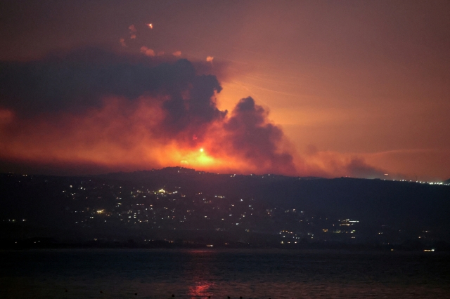 A view shows smoke and fire on the Lebanese side of the border with Israel, after Israel said it had noted armed group Hezbollah preparing to attack Israel and had carried out pre-emptive strikes on Hezbollah targets in Lebanon, as seen from Tyre, Sunday. (Reuters-Yonhap)