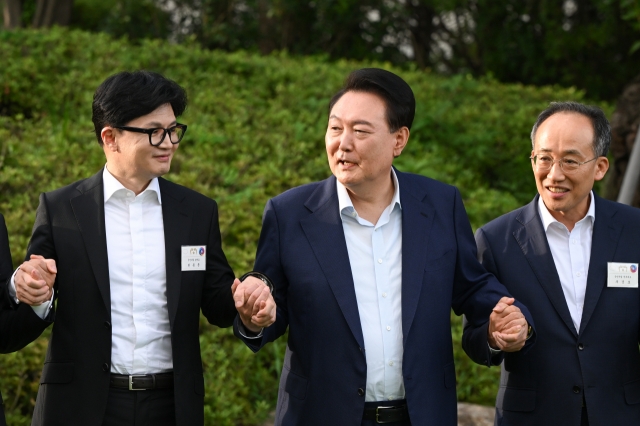 President Yoon Suk Yeol (center) poses for a photo with Han Dong-hoon (left), the leader of the ruling People Power Party, and PPP floor leader Choo Kyung-ho (right) during their dinner meeting at the presidential office in Seoul on Wednesday. (The presidential office)