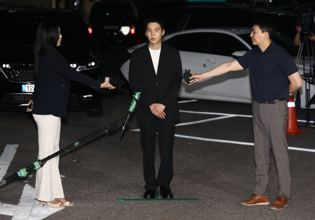 Suga of BTS speaks to reporters at Yongsan Police Station in Seoul Friday evening upon his arrival for police questioning. (Yonhap)