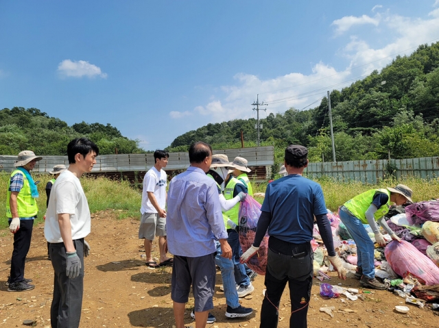 Government workers look for a trash bag that contains American dollars on Friday. (Andong City Hall)