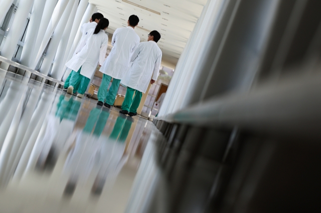 Physicians walk along an aisle in a hospital in Seoul on Aug. 19. (Yonhap)