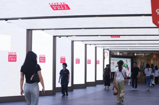 Shoppers pass by a duty-free store in central Seoul on Aug. 19. (Yonhap)